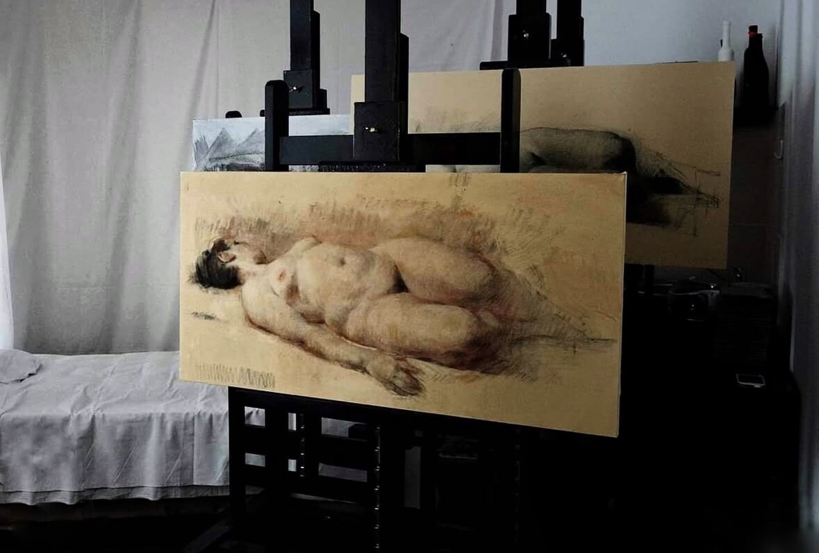 Archival photograph, 2016, APSA, Chișinău; studio view with Victor Teslaru's Reclining Female Nude Study displayed on an easel and another drawing behind it.