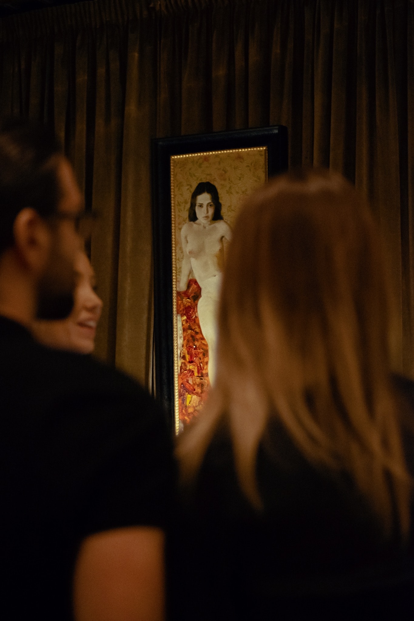Visitors and a painting in the Nudes exhibition, Bucharest, 2022.